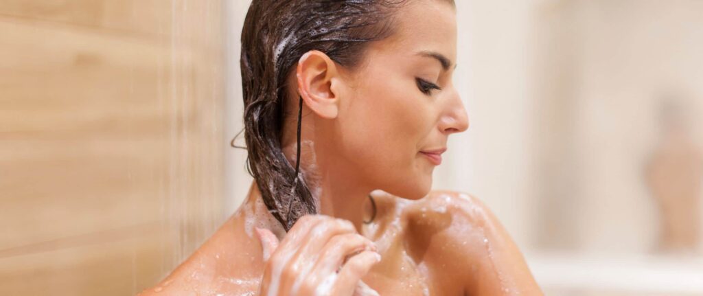 orang yang sedang membersihkan sisa shampo dari kepala