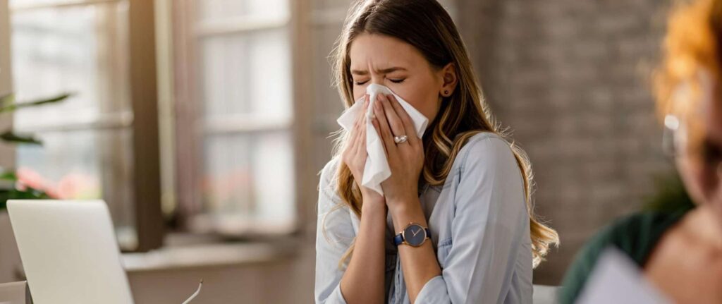 wanita bersin-bersin di ruang ber-ac