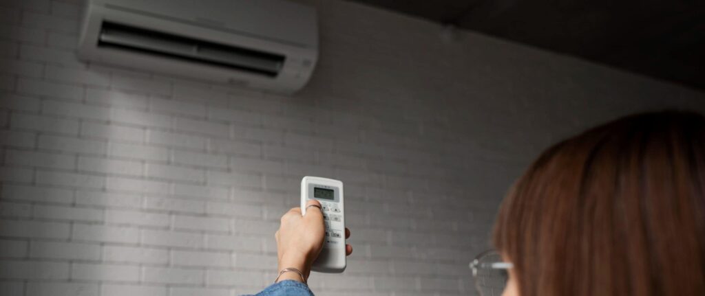 seorang wanita menyalakan AC