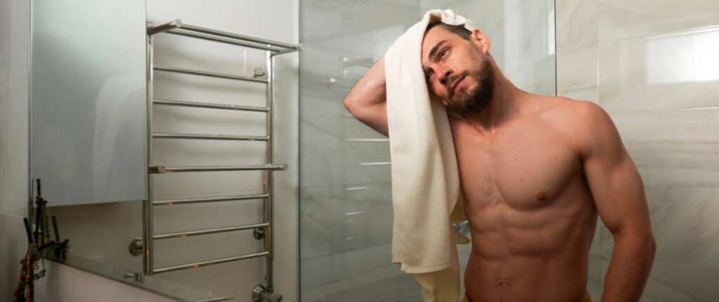 pria sedang mengeringkan rambut di depan cermin