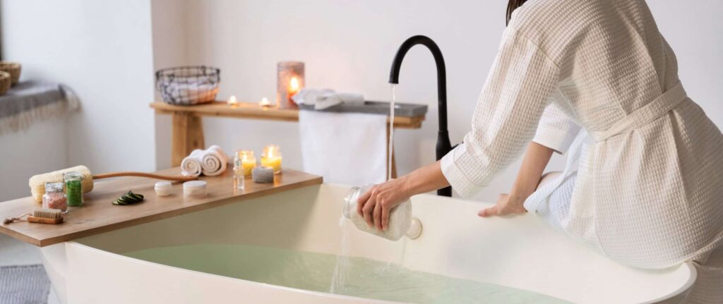 wanita sedang menuangkan garam mandi ke dalam bathtub yang berisi air wanita sedang menuangkan garam mandi ke dalam bathtub yang berisi air