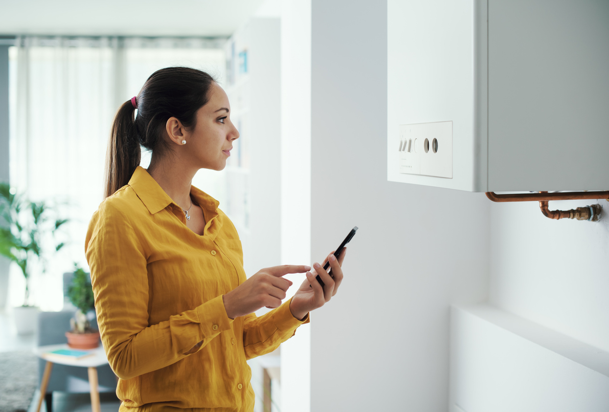 Woman managing her smart boiler using her phone