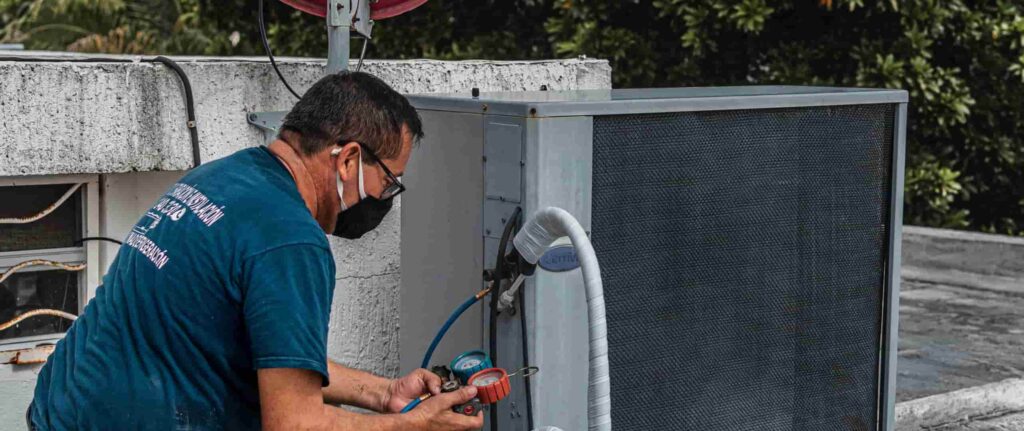 Pria sedang mengecek tekanan freon