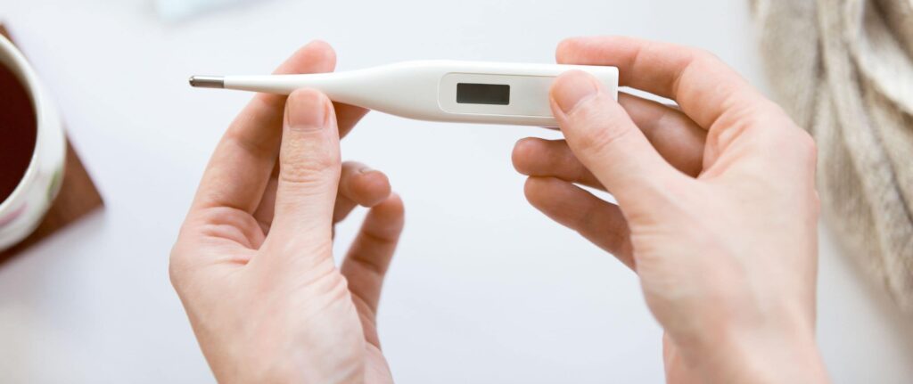 tangan orang yang memegang termometer tangan orang yang memegang termometer