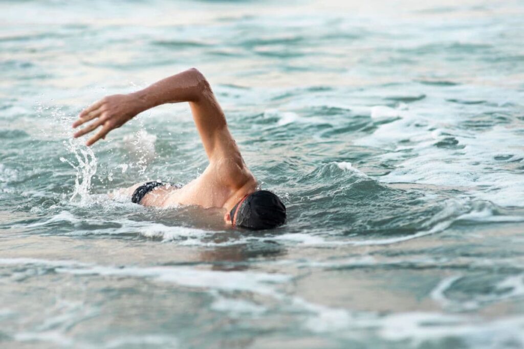 Pria melakukan renang gaya bebas di outdoor pool