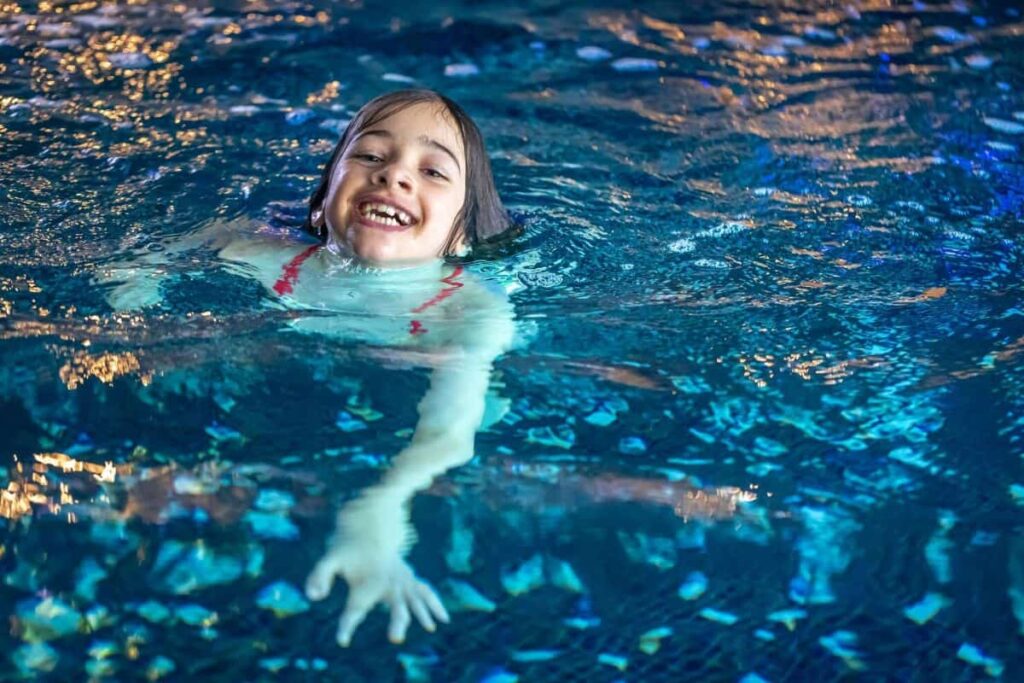 Anak perempuan mengambang di kolam renang