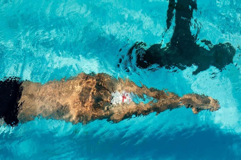 pria sedang meluncur di dalam kolam renang