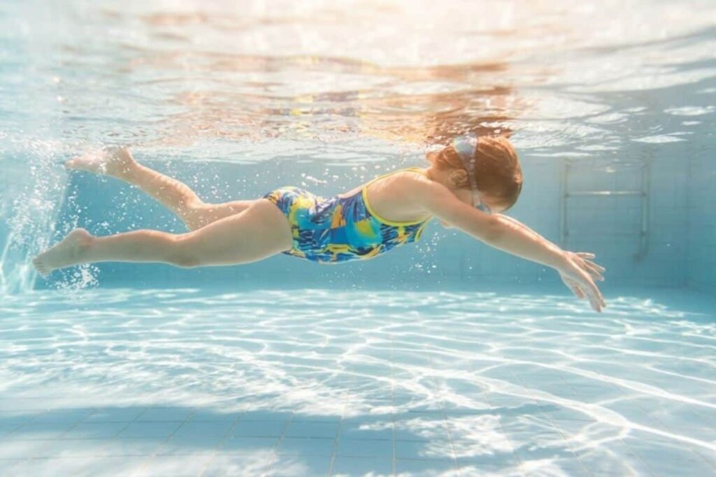 Seorang anak sedang berenang di kolam renang anak