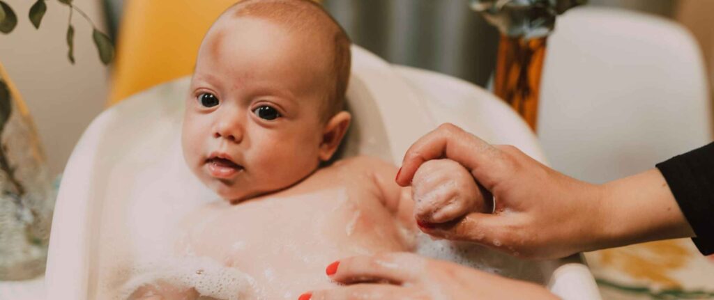 bayi sedang dimandikan di bak bayi sedang dimandikan di bak