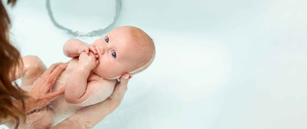 seorang wanita sedang memandikan bayi seorang wanita sedang memandikan bayi