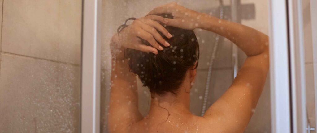 seorang wanita mandi air hangat di shower seorang wanita mandi air hangat di shower