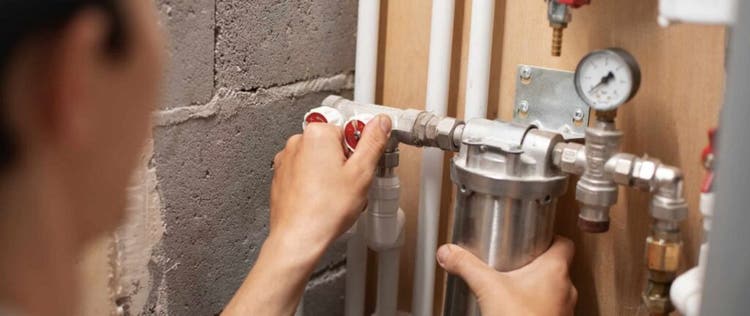 orang yang sedang memeriksa pipa water heater