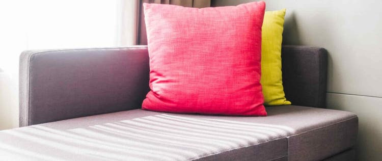 sofa bed dengan bantal merah dan kuning