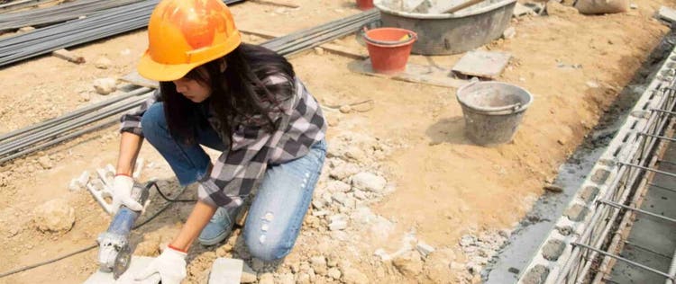 pekerja wanita sedang memotong material dengan gerinda