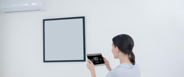 seorang wanita mengatur suhu ac dari tablet