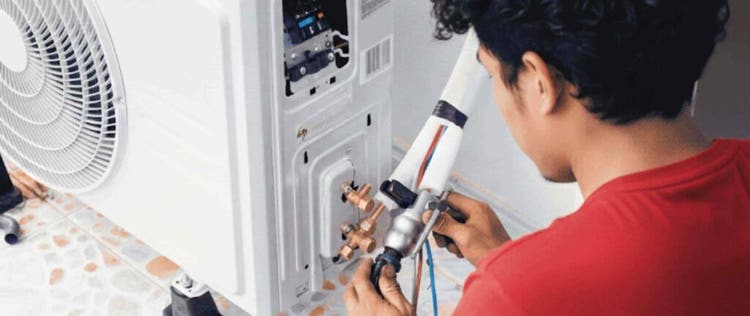 Seorang pria sedang melakukan pengecekan kebocoran freon