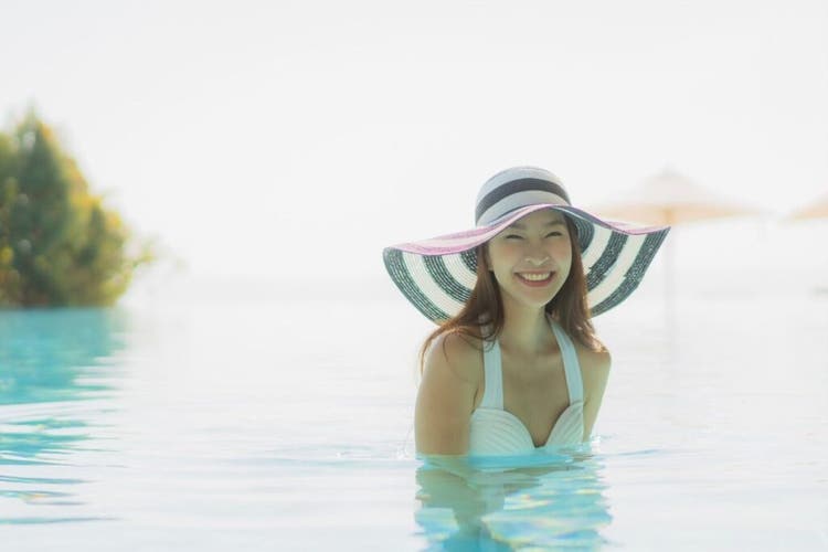 Perempuan tersenyum di kolam renang
