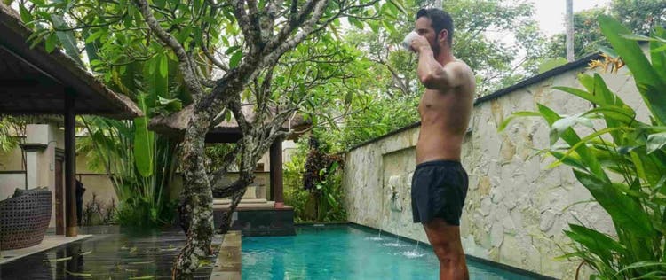 pria dengan celana pendek berdiri di tepi kolam renang
