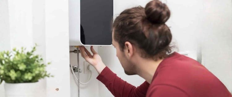 Seorang pria sedang memperbaiki water heater