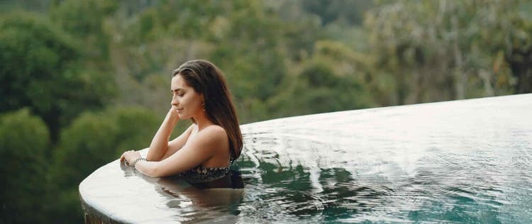 wanita sedang bersantai di kolam renang infinity