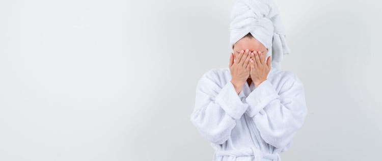 orang yang memakai handuk sambil menutup wajah