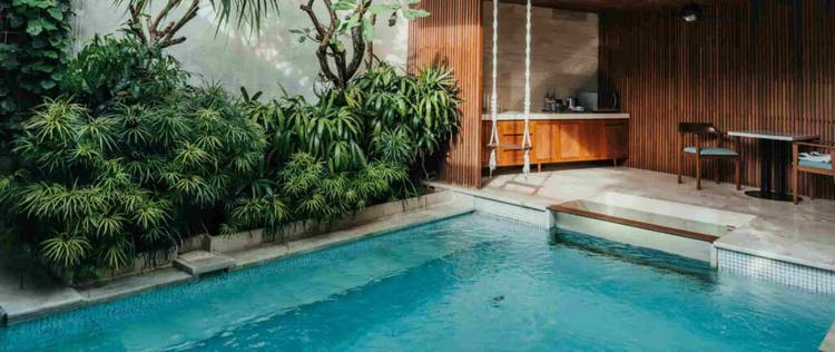 kolam renang minimalis dengan ayunan, dapur kecil, dan meja kursi